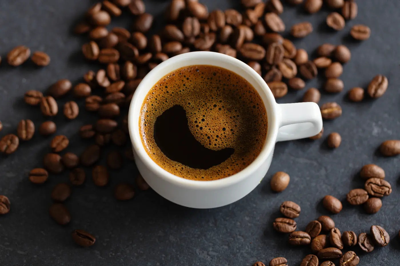 Espresso Kahve Faydaları: Fincanda kahve ve yanındaki kahve çekirdekleri ile sağlıklı bir içecek.
